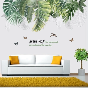 Detail of tropical green leaf wall decals with butterflies and birds in a living room