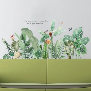 Detail of tropical plant wall stickers with watercolor green leaves and birds on white wall
