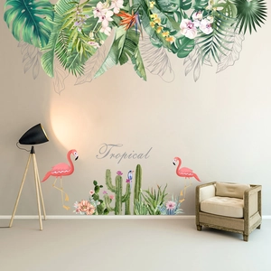 Detail of tropical wall stickers featuring green leaves, flamingos and cacti in a living room