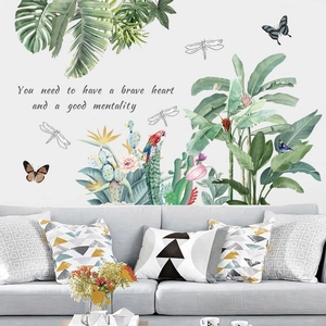 Detail of tropical palm leaf wall decals with birds and motivational quotes on white wall