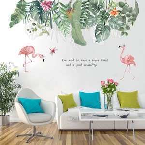 Detail of tropical flamingo wall decals with green leaves and inspirational quote on a white wall