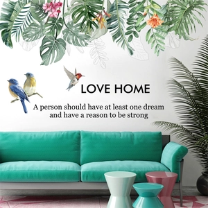 Detail of tropical monstera leaves and birds wall decals with Love Home quote