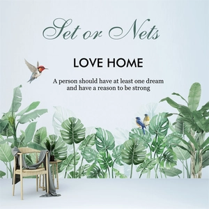 Detail von tropischen Wandstickern mit Monstera-Blättern, Vögeln und Love Home-Schriftzug