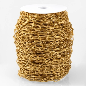 Gold stainless steel cross O-chain with spiral texture wound on a white spool roll
