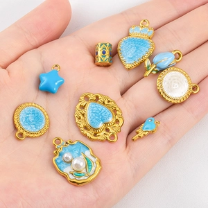 Golden stainless steel enamel pendants with blue floral and crown designs for DIY jewelry