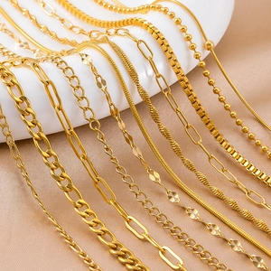 Golden stainless steel chain assortment including snake and box styles on satin fabric