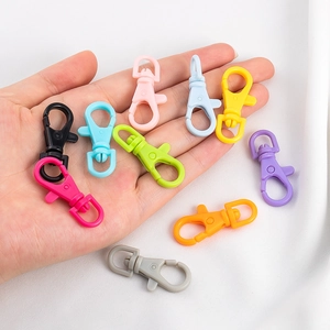 Colorful plastic lobster clasps held in hand showing various vibrant DIY colors