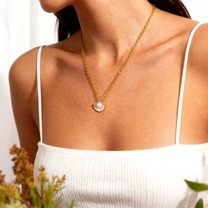 Golden mermaid style necklace featuring a pearl seashell pendant worn by a model