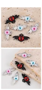 Detailed view of Gothic bat devil eye alloy charms in black and silver finishes