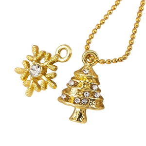 Gold Christmas snowflake and tree charms with rhinestones on a minimalist background