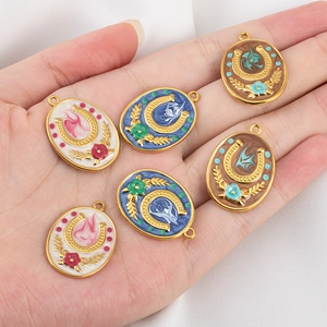 Handheld view of vintage horseshoe pendants with colorful enamel flowers for DIY jewelry
