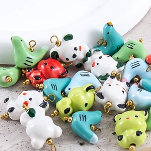 Variété de pendentifs animaux en céramique avec boucles dorées, incluant panda et oiseau
