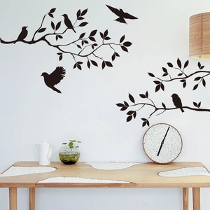 Detailed view of black bird and branch silhouette wall decals on a clean white living room wall