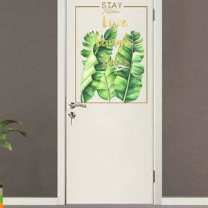 Detail of tropical banana leaf wall sticker with golden Live Laugh Love typography