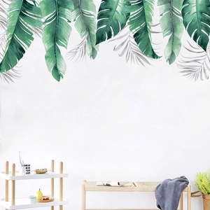 Détail de stickers muraux feuilles de bananier tropicales style aquarelle sur mur de salon