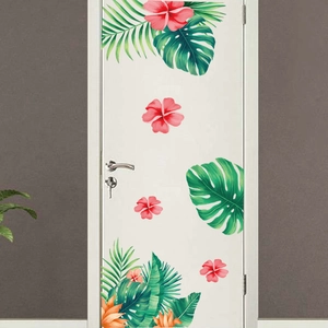 Détail de stickers muraux feuilles de monstera et hibiscus rose sur une porte blanche
