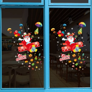 Stickers de Noël avec Père Noël en avion et cadeaux sur une vitre bleue de balcon