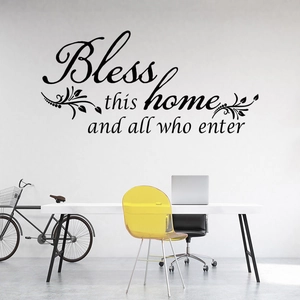 Détail du sticker mural Bless this home avec décor de feuilles élégantes sur mur blanc