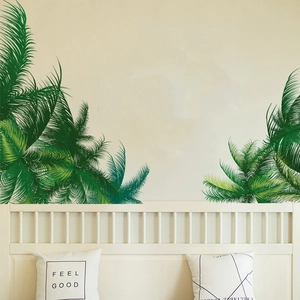 Detail view of green palm leaf wall stickers applied to a minimalist bedroom wall