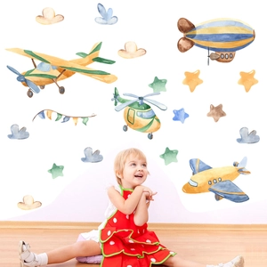 Child looking at watercolor airplane and spaceship wall stickers in a cozy bedroom
