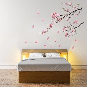 Elegant wall decal featuring cherry blossom branches and pink petals on a white wall