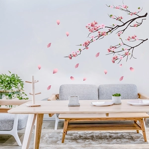 Detail of pink cherry blossom wall decal branch with flying petals in a cozy living room