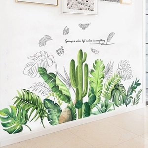 Detail of tropical green leaf wall decals with monstera and butterfly motifs on a white wall