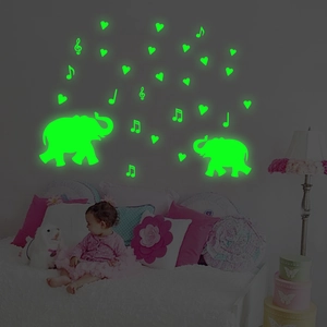 Luminous wall stickers featuring cartoon elephants, hearts and musical notes in the dark
