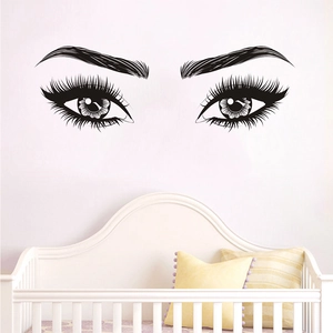 Artistic black eyelash wall sticker decoration in a cozy bedroom nursery setting