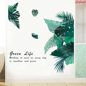 Detailed view of tropical green palm and monstera leaf wall stickers on a white surface