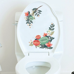 Détail de stickers pour abattant de WC avec fleurs rouges et feuilles sur fond blanc