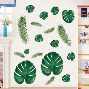 Close-up of tropical monstera and palm leaf wall stickers on a clean white wall