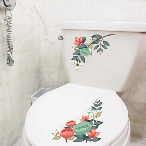 Détail de stickers floraux colorés appliqués sur un réservoir et couvercle de WC