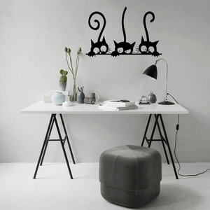 Detailed close-up of three black cat silhouette wall stickers in a modern office setup