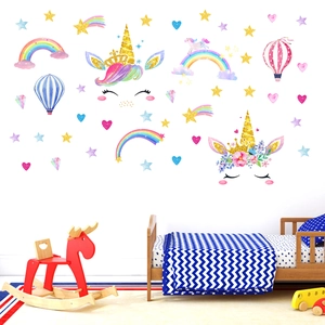 Unicorn wall decals set with rainbows and stars decorating a cozy child's bedroom wall