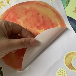 Detail showing the easy-to-peel adhesive backing of the watercolor solar system wall decal
