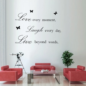 Live Love Laugh wall decal with butterflies above a modern red sofa in a living room