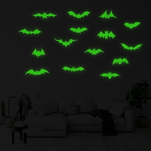 Luminous bat wall stickers glowing in bright green inside a dark living room setting