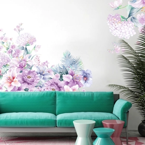 Détail de stickers muraux pivoines violettes au-dessus d'un canapé vert menthe