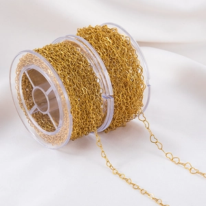 Golden stainless steel heart link chain roll for DIY jewelry making on white background