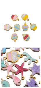 Macro-opname van emaille cupcake en zeester bedeltjes met gouden rand en spiegeling