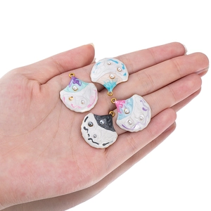 Gradient shell pendant set with inlaid pearls and gold rings on white background