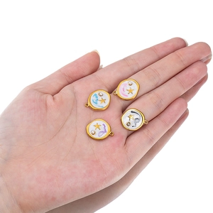 Handheld view of four colorful stainless steel enamel round star pendants for jewelry DIY