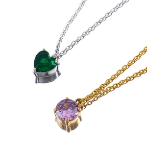 Elegant gold and silver heart and round gemstone pendant necklaces on white background