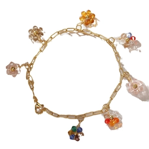 Goldenes Armband mit sieben bunten Kristall-Gänseblümchen-Anhängern und Karabinerverschluss