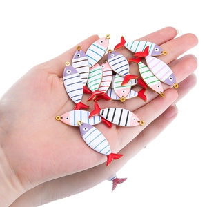 Striped fish-shaped stainless steel charms for DIY jewelry making held in hand