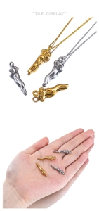Detailed macro view of gold and silver cornicello pepper pendants with crown tops