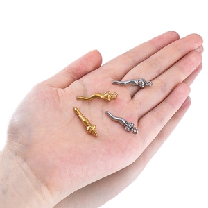 Golden and silver stainless steel chili pepper pendants held in hand on white background