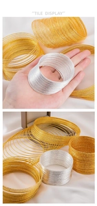 Detail view of multi-layer metallic bracelets in gold and silver textured finish