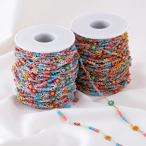 Daisy enamel floral charms on copper chains with colorful beads on white spools